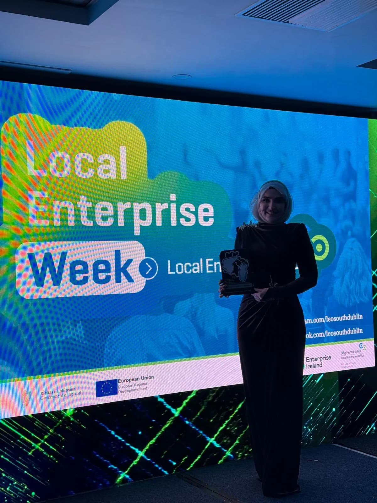 Dr. Elif Torun on stage at Local Enterprise Week, holding her award
